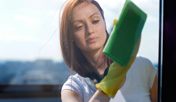 mujer en guantes limpiando ventana con trapo en casa - microfiber fotografías e imágenes de stock