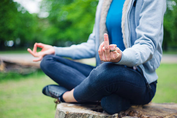 Woman in meditation pose displaying rude gesture stock photo