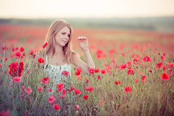 Woman in poppy field stock photo