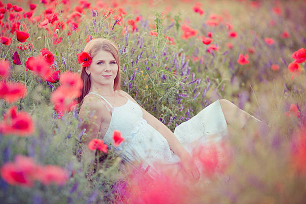 Woman in poppy field stock photo