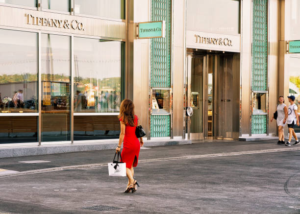 mujer en vestido rojo va a tiffany tienda en ginebra - tiffany usa fotografías e imágenes de stock