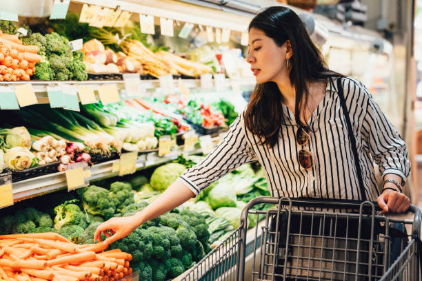 ショッピングカートを押すスーパーマーケットの女性 - スーパー ストックフォトと画像