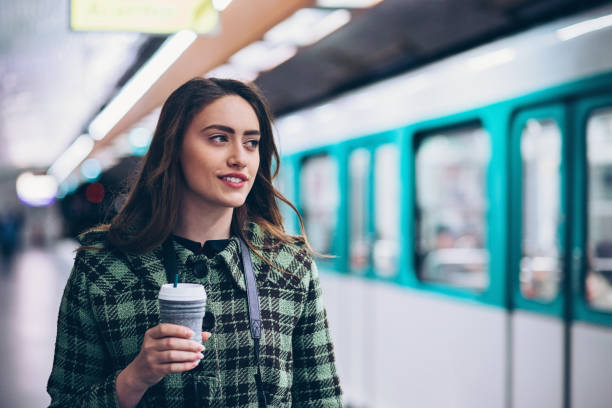 vrouw in de metro - walking with coffee stockfoto's en -beelden