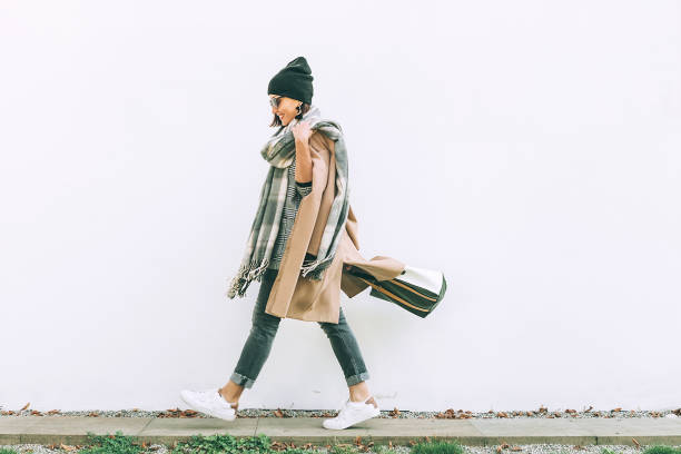 Woman in trend multilayered outfit walks in autumn city street. Fashion street trends Woman in trend multilayered outfit walks in autumn city street. Fashion street trends indian women walking stock pictures, royalty-free photos & images