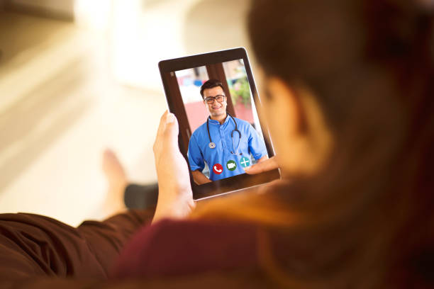 Woman in video conference with doctor Sick woman video conferencing with doctor using digital tablet nurse talking to camera stock pictures, royalty-free photos & images