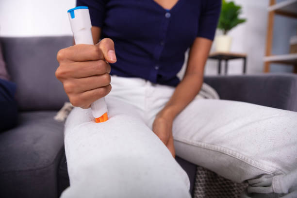 Woman Injecting Epinephrine Using Auto-injector Syringe Woman Injecting Epinephrine Using Auto-injector Syringe As An Emergency Treatment For Allergic Reaction adrenaline stock pictures, royalty-free photos & images