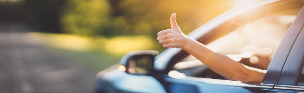 Woman inside her car gesticulate thumb up stock photo