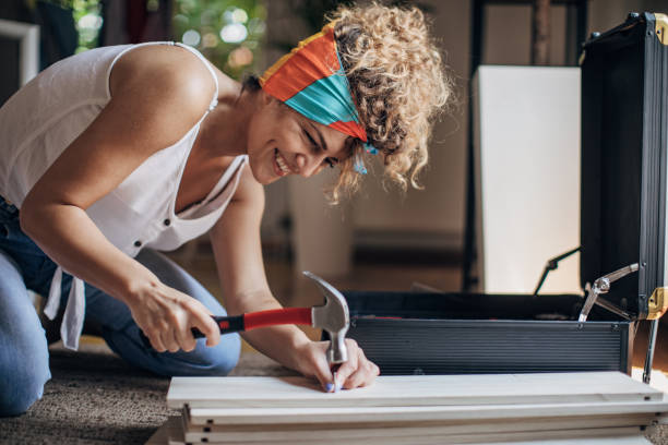 Woman is assembling shelf at home stock photo