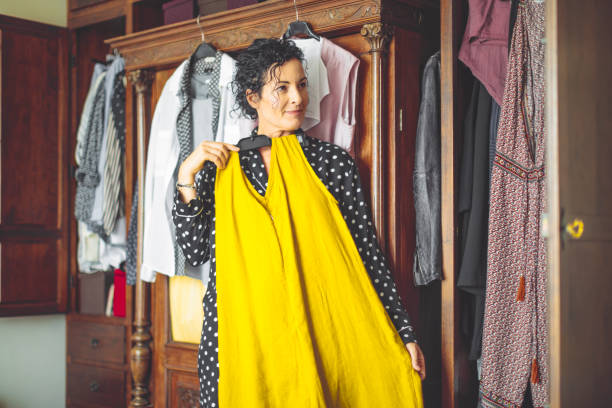 woman is choosing the right dress to wear - clothes wardrobe imagens e fotografias de stock