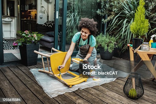 istock Woman is coloring a chair at home 1255615584
