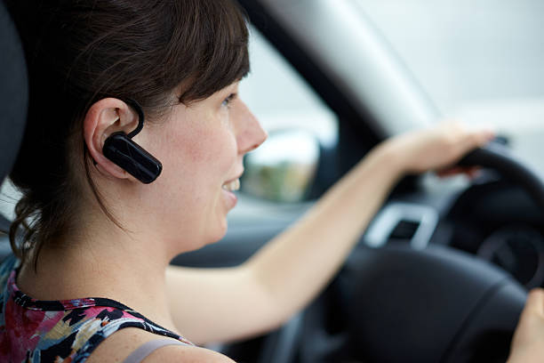 woman is safely talking phone in a car with headset stock photo