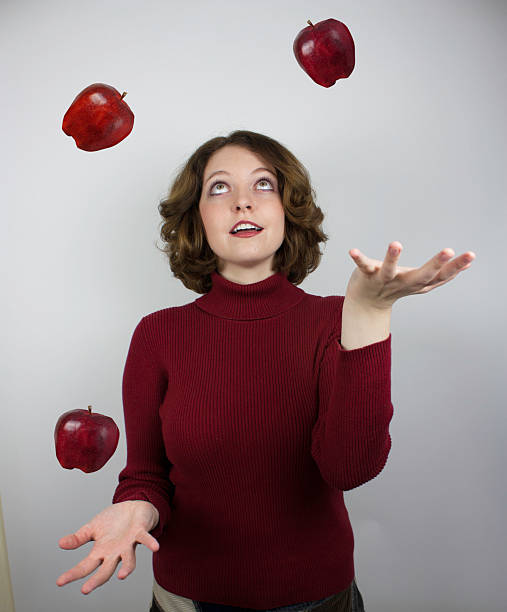 Woman juggling apples stock photo