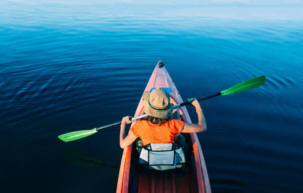 vrouw kayaking op een ongerepte lake, bovenaanzicht - kajak stockfoto's en -beelden