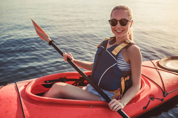 kvinna som kajakpaddling på sunset - woman kayaking bildbanksfoton och bilder