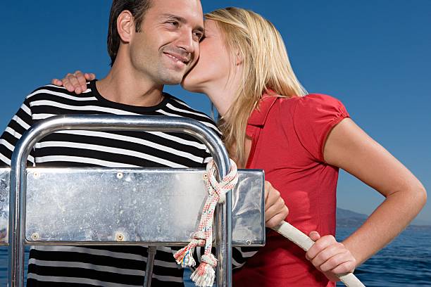 woman kissing man - fluisterboot stockfoto's en -beelden