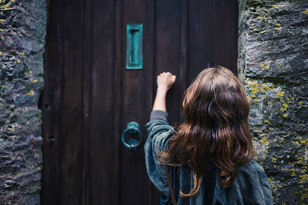 Woman knocking on door stock photo