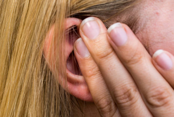Woman lays finger on the ear stock photo