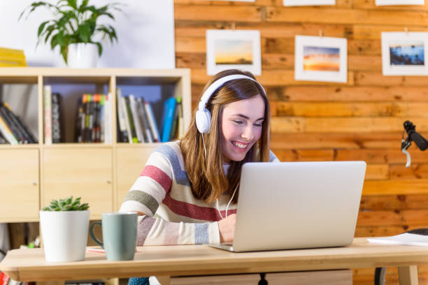 Woman learning with headphones in laptop stock photo
