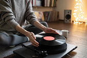 istock Woman listening music, relaxing, enjoying life at home. Turntable playing vinyl LP record 1291156945