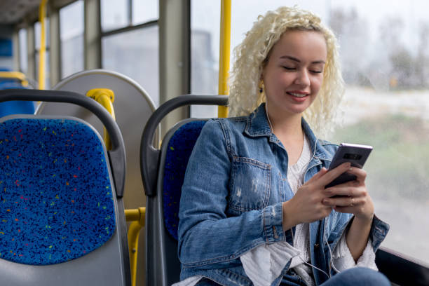 femme écoutant la musique dans le bus - smartphone car photos et images de collection