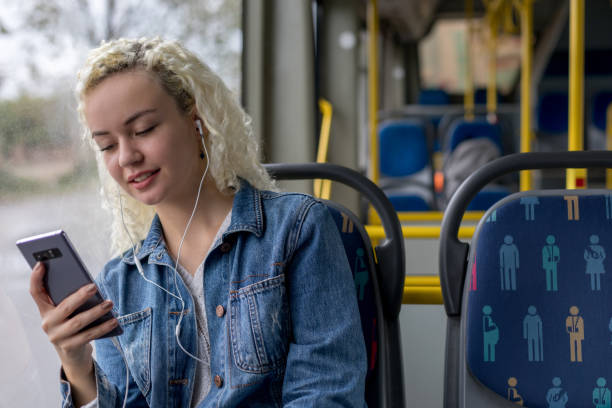 femme écoutant la musique dans le bus - smartphone car photos et images de collection