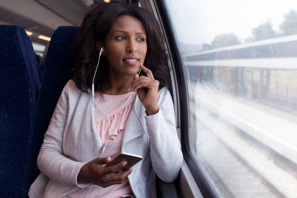 femme écoutant de la musique dans le train. - smartphone car photos et images de collection