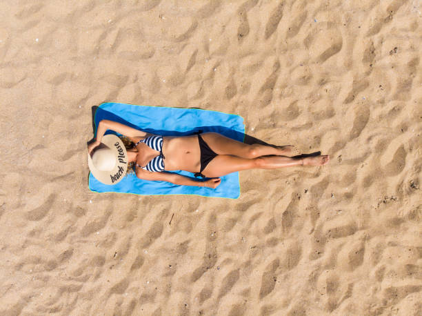 Woman lying on the beach stock photo