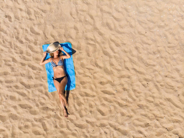 woman lying on the beach - beach towel imagens e fotografias de stock