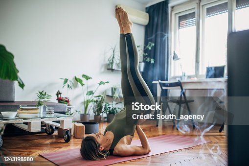 istock Woman lying on upper back and holding her lower back in balance 1243198580