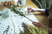 乾燥した花でスワッグを作る女性