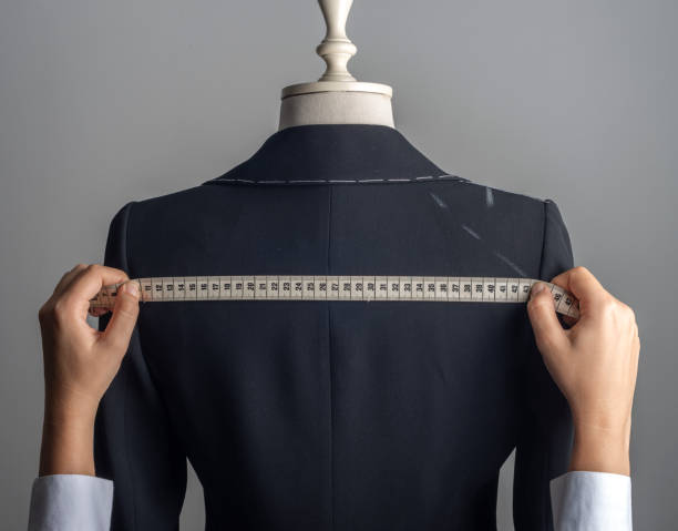 Woman Measuring Jacket on Male Dress Form Woman measuring jacket on tailor mannequin. tailor stock pictures, royalty-free photos & images