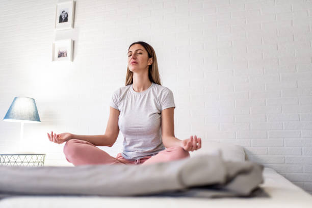 Woman meditating in the bedroom. stock photo