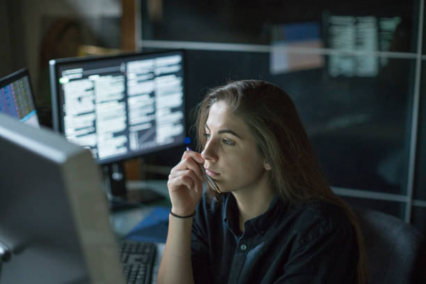 Woman monitors dark office stock photo