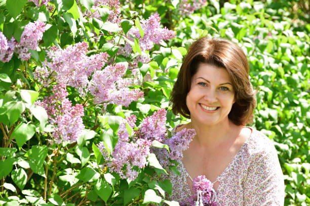 woman near blooming lilac stock photo