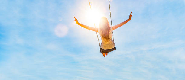 woman on a swing with blue sky - alegria imagens e fotografias de stock