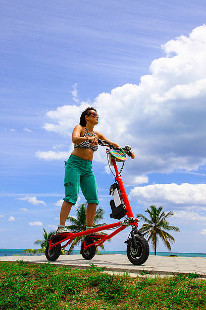 Woman on an electric tricycle in Miami Woman on an electric tricycle in Miami adult tricycle stock pictures, royalty-free photos & images