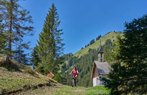 woman on electric mountainbike in Tirol, Austria nice senior woman riding her electric mountain bike in the Lech Valley mountains near Reutte in Tirol, Austria lechtal alps stock pictures, royalty-free photos & images