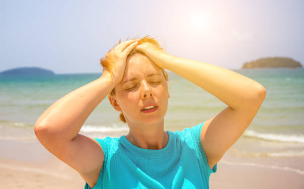 Woman on hot beach with sunstroke. Health problem on holiday. Medicine on vacation. stock photo