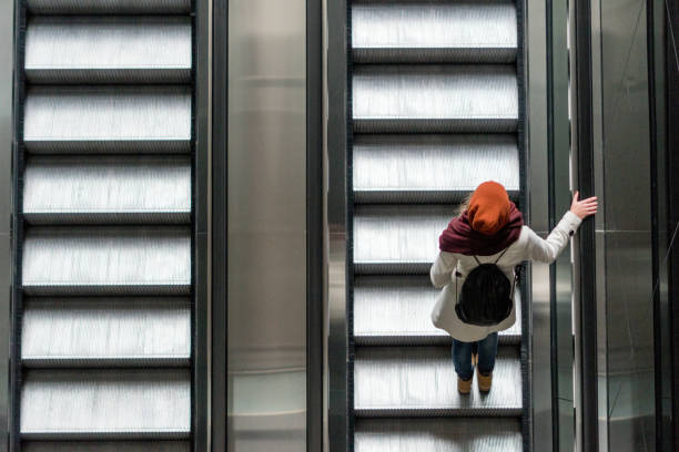 woman on the escalator moving up - stairs subway imagens e fotografias de stock