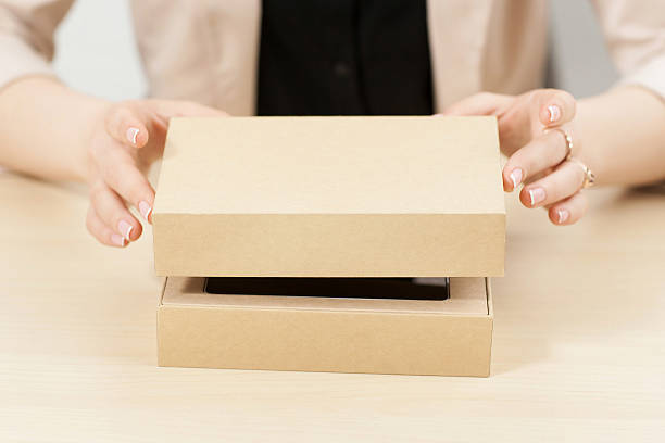 Woman opening box with new parcel, close-up stock photo