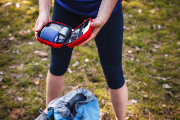 Woman opening first aid kit outdoors stock photo