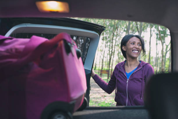 woman packing car trunk. - fechar porta bagagens imagens e fotografias de stock