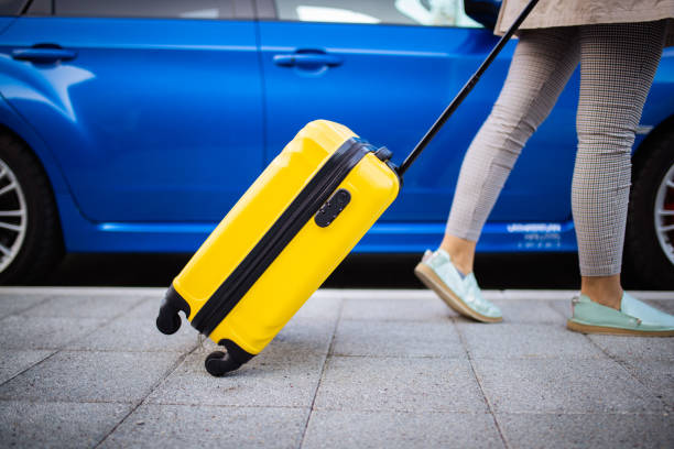 Woman packing her car with luggage bags stock photo