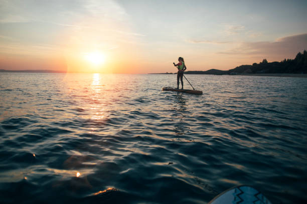 Woman paddleboarding on sea stock photo