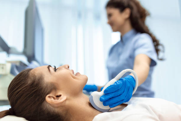 Woman patient receives thyroid diagnostics. Treatment of thyrotoxicosis, and hypothyroidism. Ultrasound diagnostics of the endocrine system and thyroid stock photo