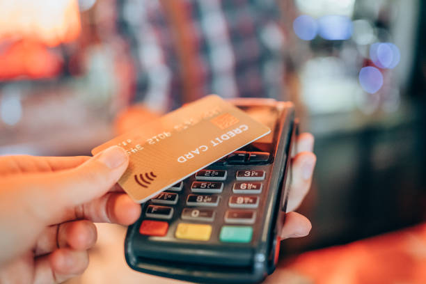 Woman paying contactless with credit card at the restaurant. stock photo