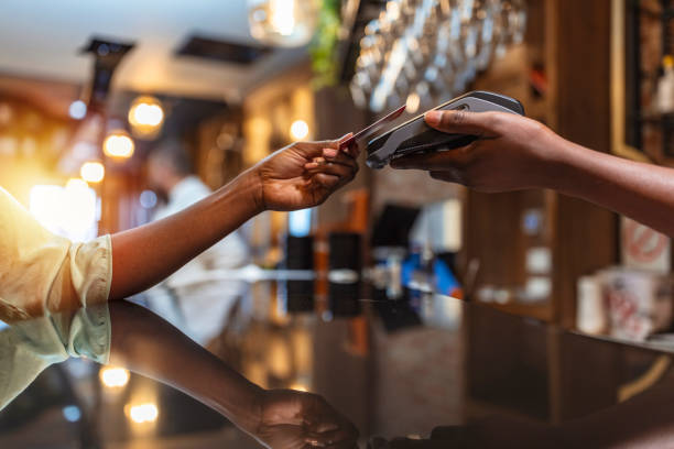 Woman paying with mobile phone at bar stock photo