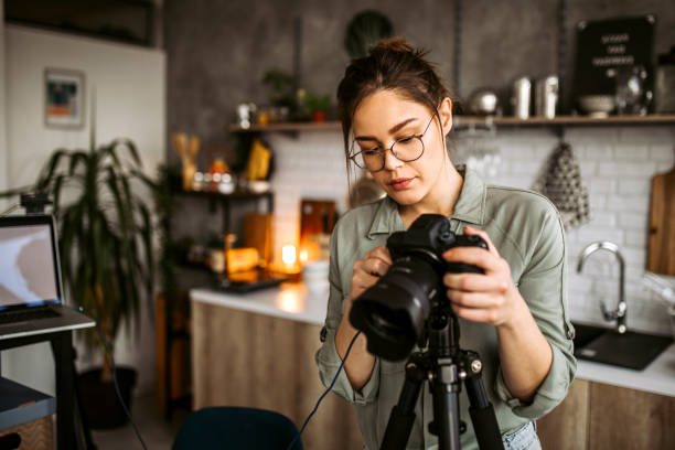 Woman photographer preparing photo equipment for shooting stock photo