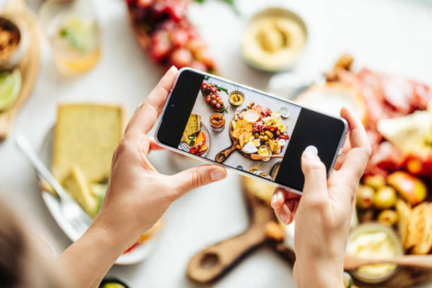Woman photographing fresh meze on table Cropped hands of woman photographing meal. High angle view of fresh meze on table. She is using smart phone. canape photos stock pictures, royalty-free photos & images