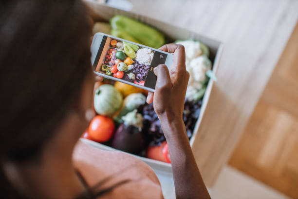 mujer fotografiando comestibles en comidakit - caja fotos fotografías e imágenes de stock